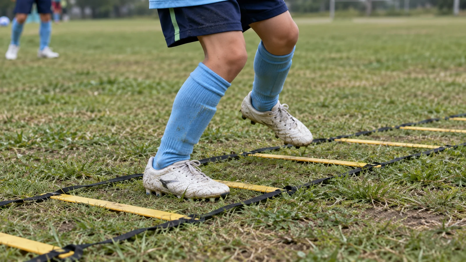 空色のソックスと白いスパイクでラダーを踏み分ける小学生選手の足元
