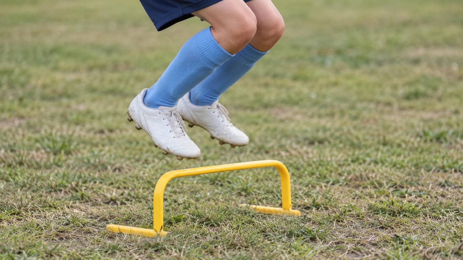 低いミニハードルを跳び越える小学生選手の足元