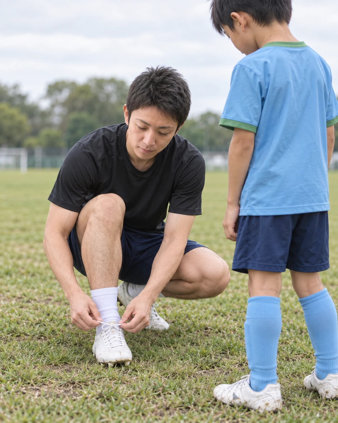 白いスパイクの準備を通して体験参加の小学生選手をサポートするコーチ